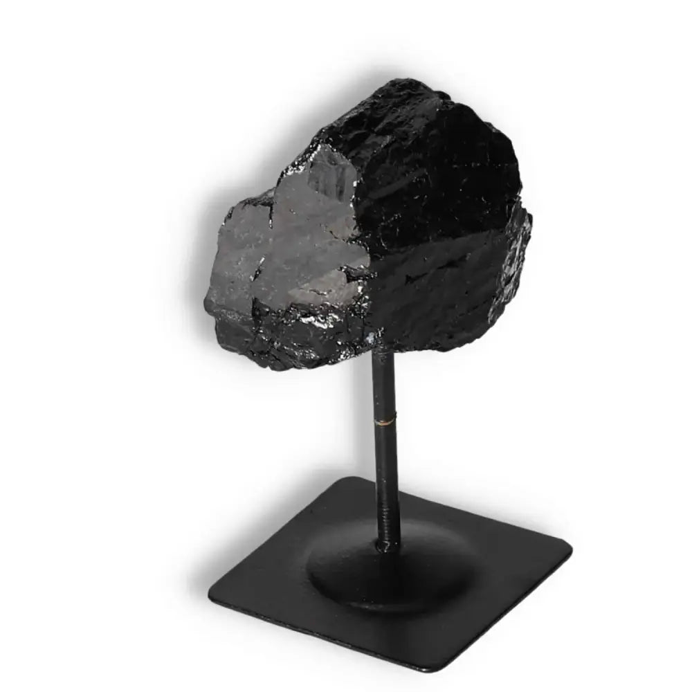 Rough Black Tourmaline on a Metal Stand from Sylvia Crystals, known for cleansing negative energies. Perfect for luxury home decor.