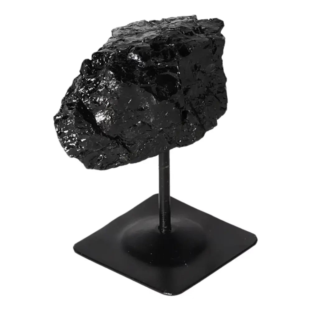 Rough black tourmaline on metal stand enhancing space with spiritual benefits, ideal for cleansing negative energies.