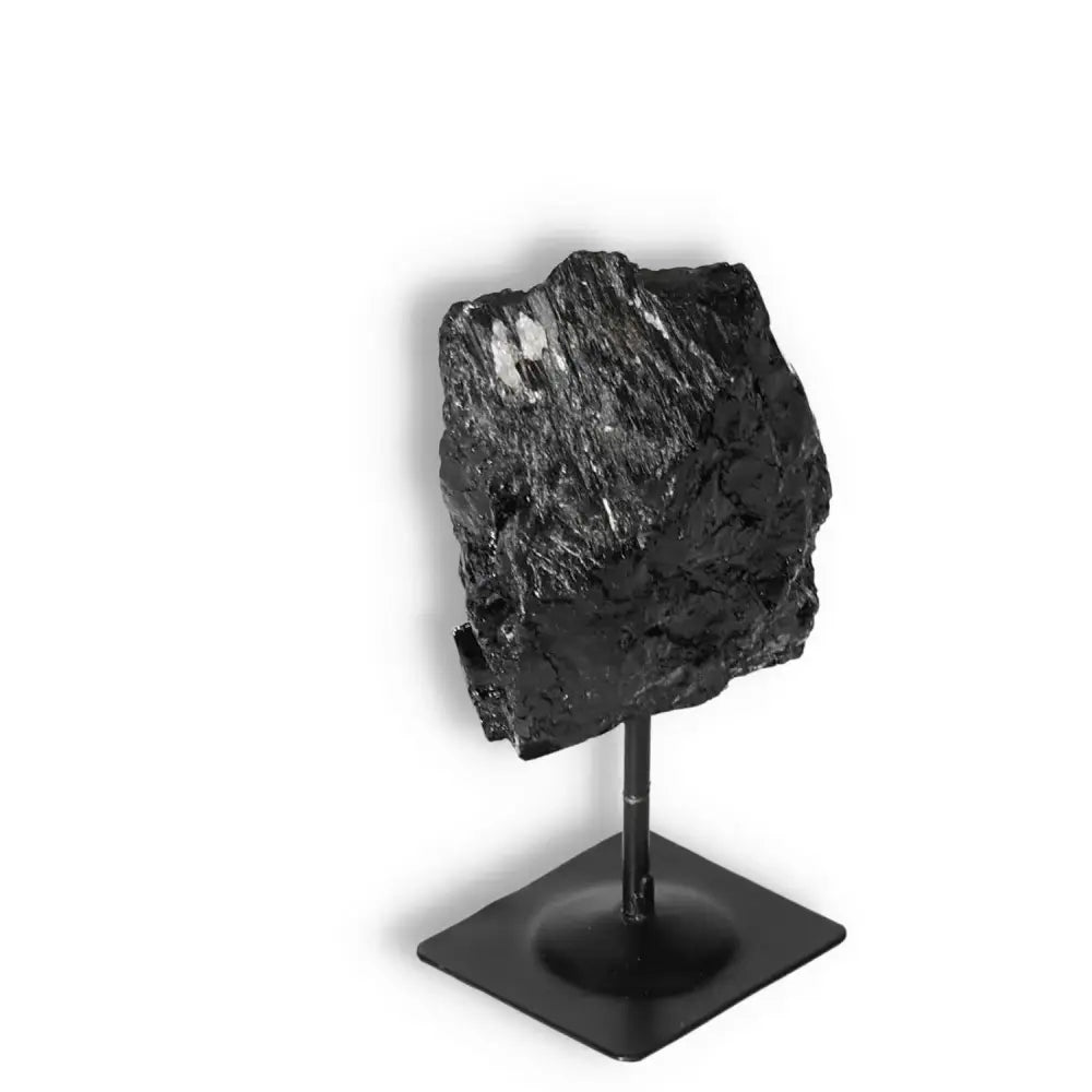 Rough Black Tourmaline on Metal Stand, premium décor by Sylvia Crystals, known for cleansing and transformation, enhances stability.