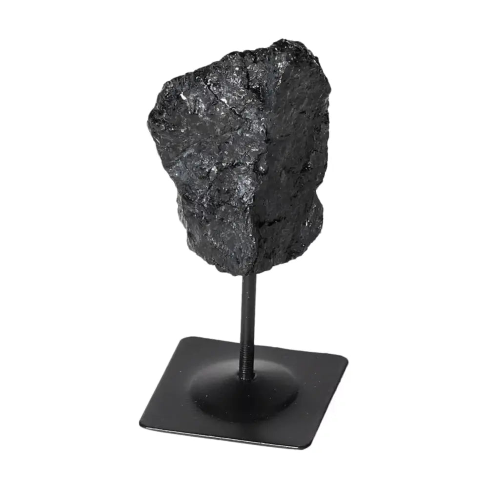 Rough Black Tourmaline on metal stand, premium crystal from Sylvia Crystals, known for energy cleansing and grounding stability.