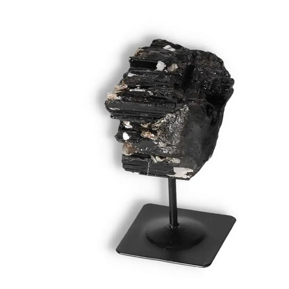 Rough black tourmaline on metal stand from Sylvia Crystals for energy cleansing and spiritual balance.