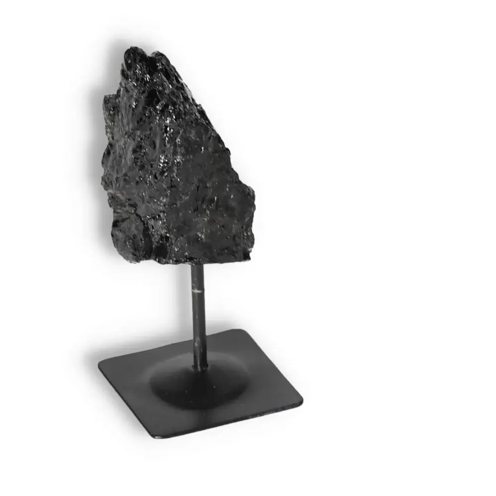 Rough Black Tourmaline on metal stand by Sylvia Crystals, known for cleansing negative energies and high-quality selection.