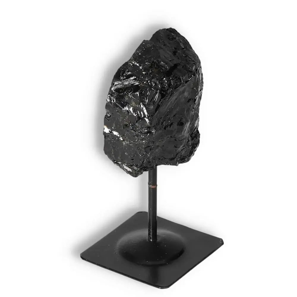 Rough Black Tourmaline on a metal stand from Sylvia Crystals, showcasing powerful energy-cleansing properties.