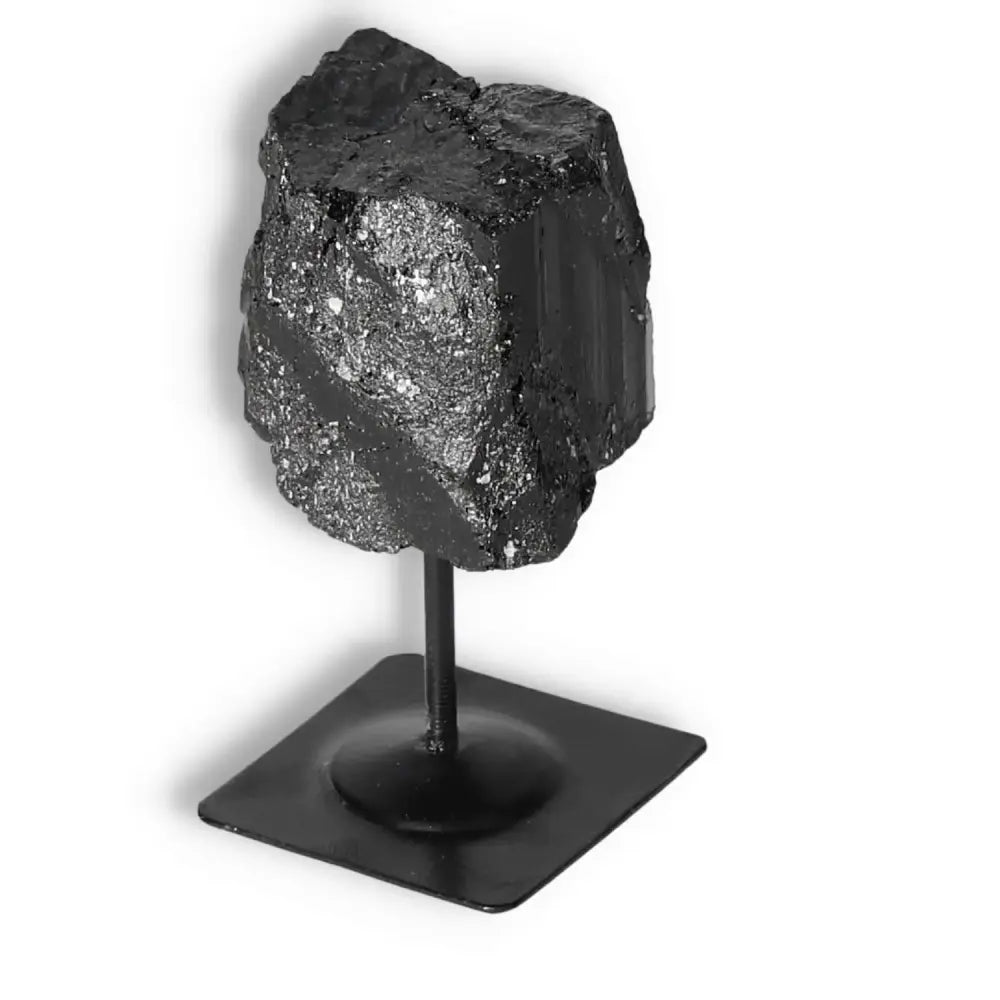 Rough Black Tourmaline on metal stand, premium quality from Sylvia Crystals, known for cleansing negative energies and enhancing stability.