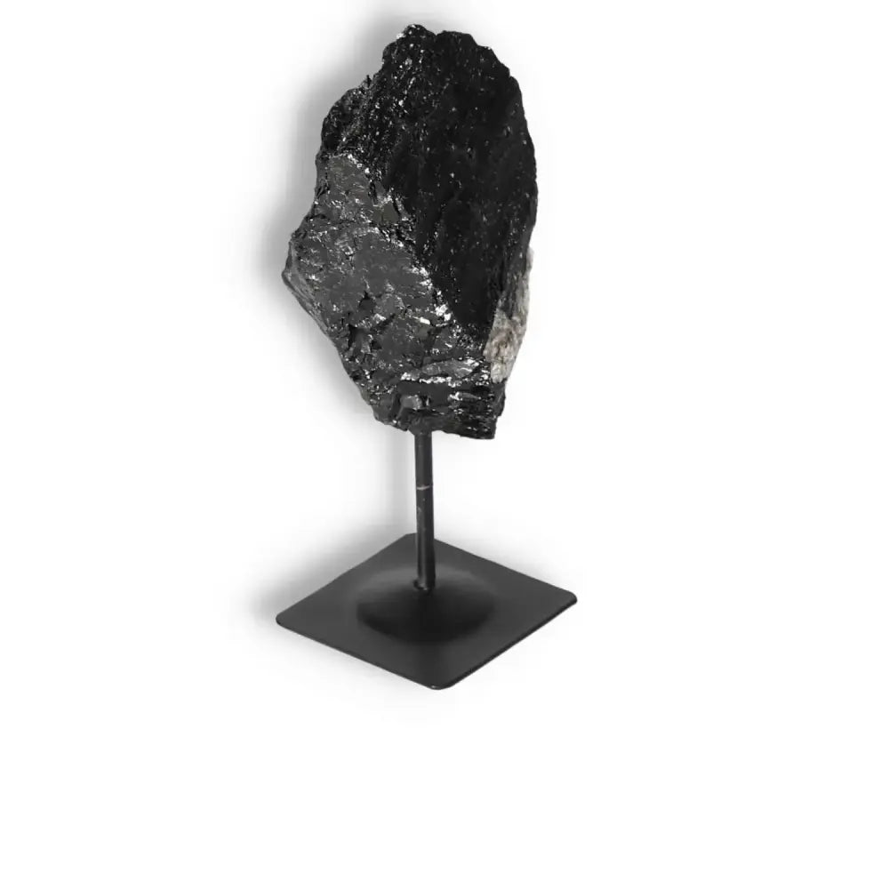 Rough Black Tourmaline with metal stand by Sylvia Crystals, known for cleansing energy and grounding properties.