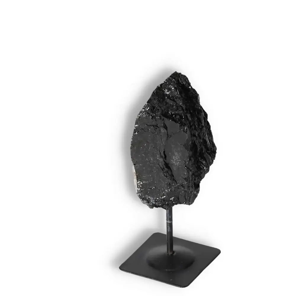 Rough Black Tourmaline on metal stand from Sylvia Crystals, symbolizing grounding and cleansing properties, perfect for home decor and energy balancing.