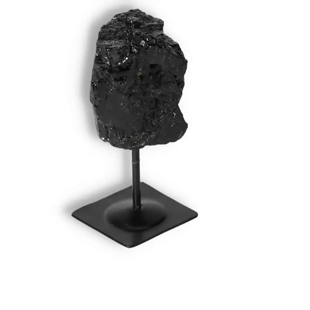 Rough Black Tourmaline on metal stand, Sylvia Crystals product for energy cleansing and balance, supports root chakra.