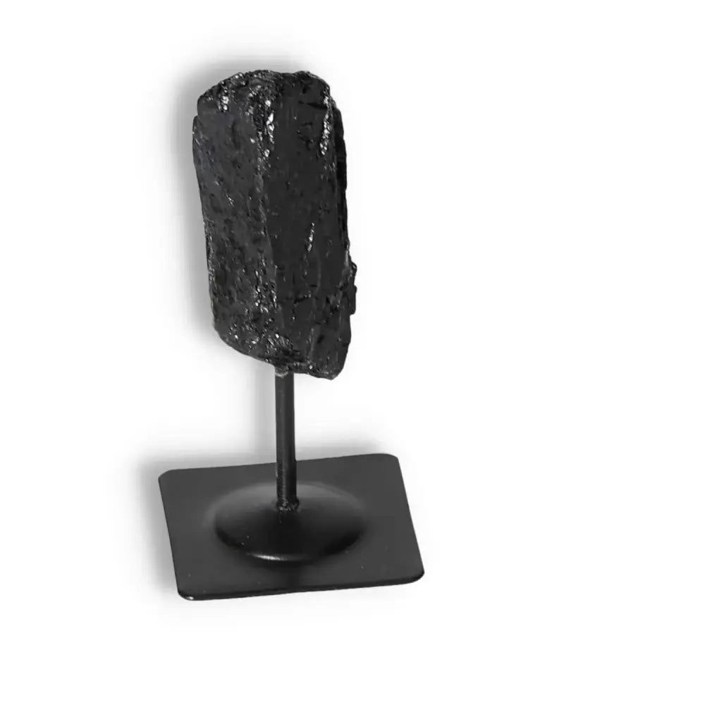 Rough Black Tourmaline on a metal stand, perfect for energy cleansing and transformation, offered by Sylvia Crystals.
