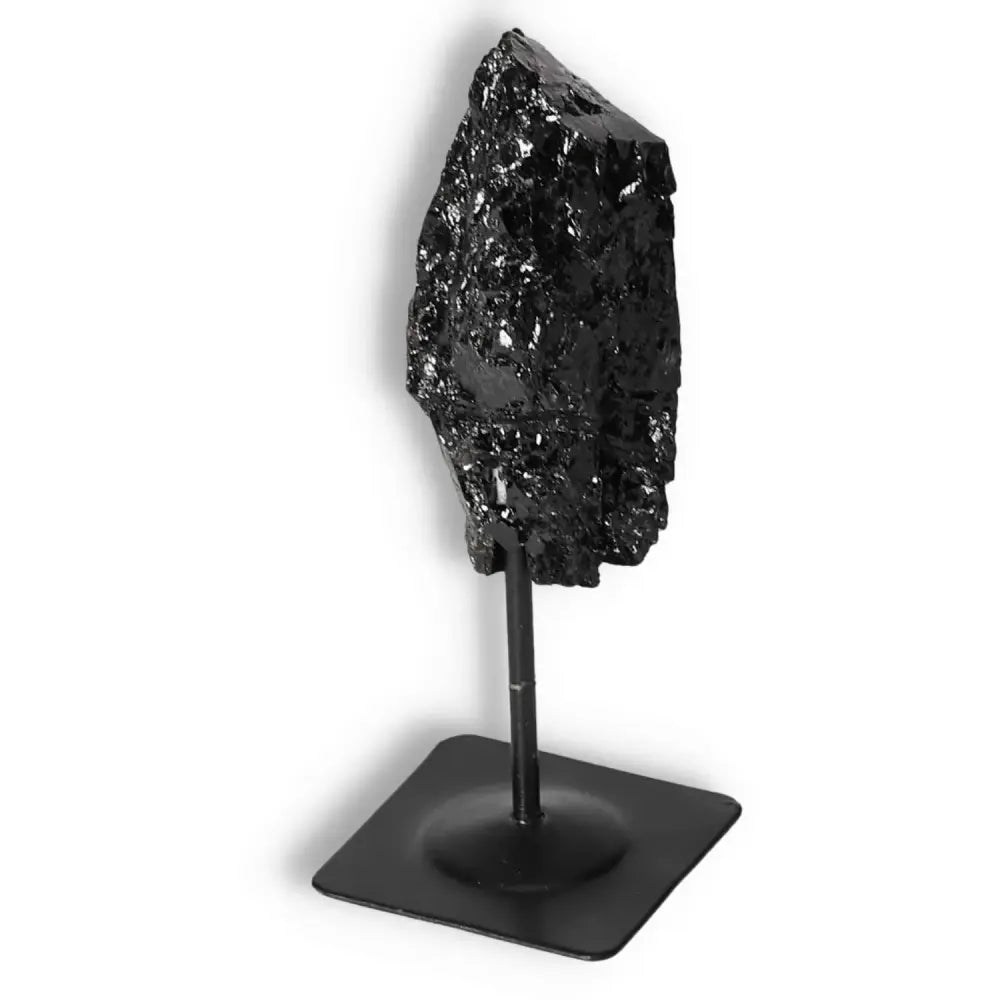 Rough Black Tourmaline with Metal Stand S by Sylvia Crystals, a powerful tool for dissipating negative energies and emotional healing.
