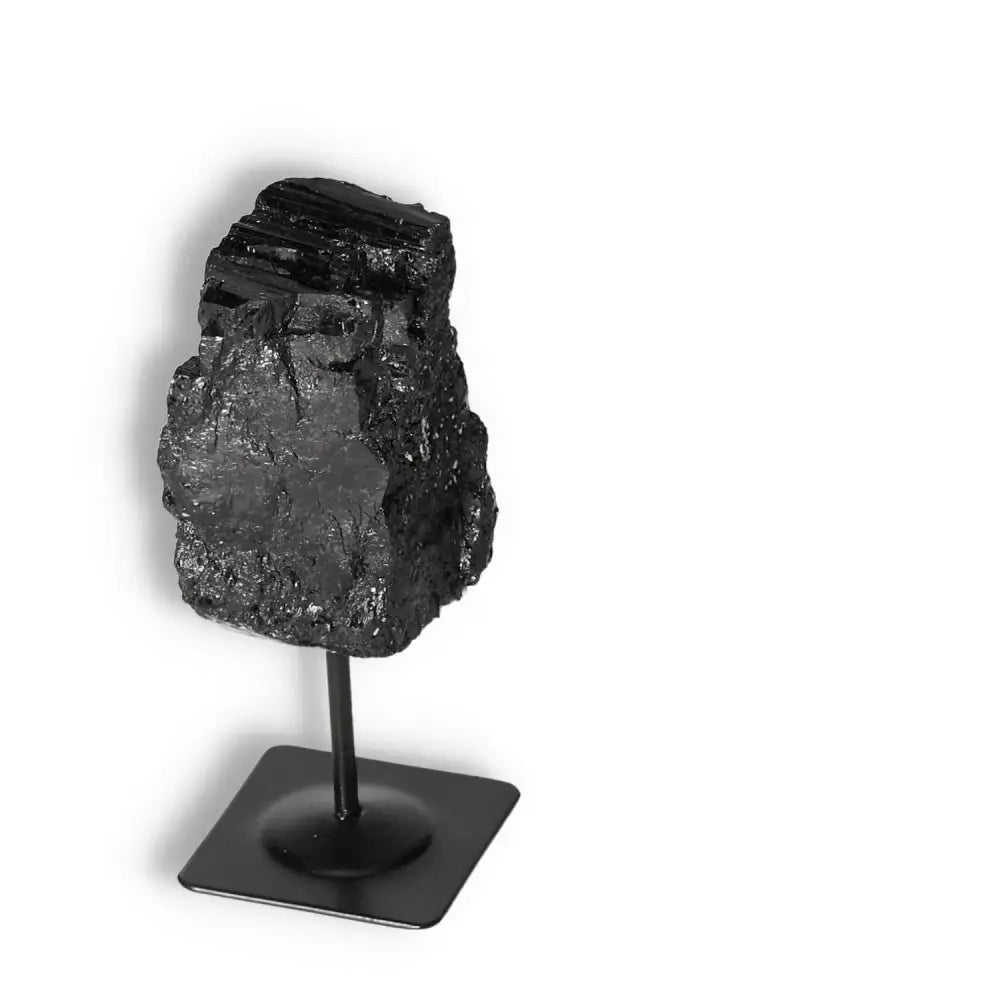 Rough Black Tourmaline crystal on metal stand, premium quality from Sylvia Crystals, known for cleansing and transforming negative energies.