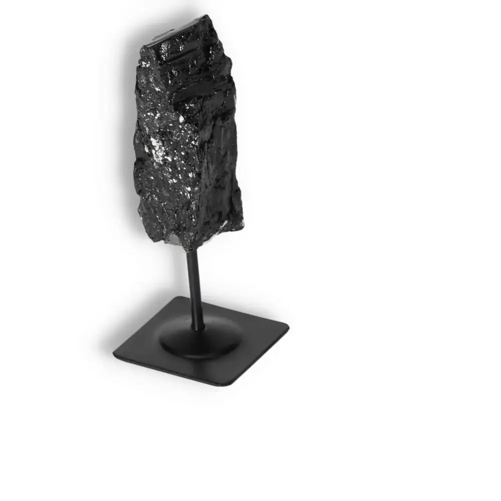 Rough Black Tourmaline on metal stand, offering energy cleansing by Sylvia Crystals, premium quality for discerning collectors.