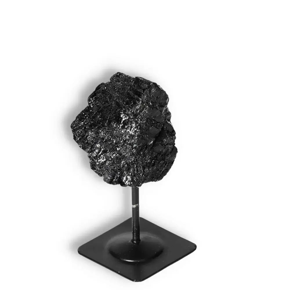 Rough black tourmaline on a metal stand, ideal for spiritual cleansing and decor. Premium quality from Sylvia Crystals.