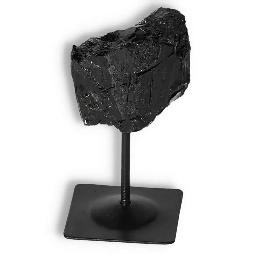 Rough Black Tourmaline on a sleek metal stand from Sylvia Crystals, offering transformative energy and high-quality craftsmanship.