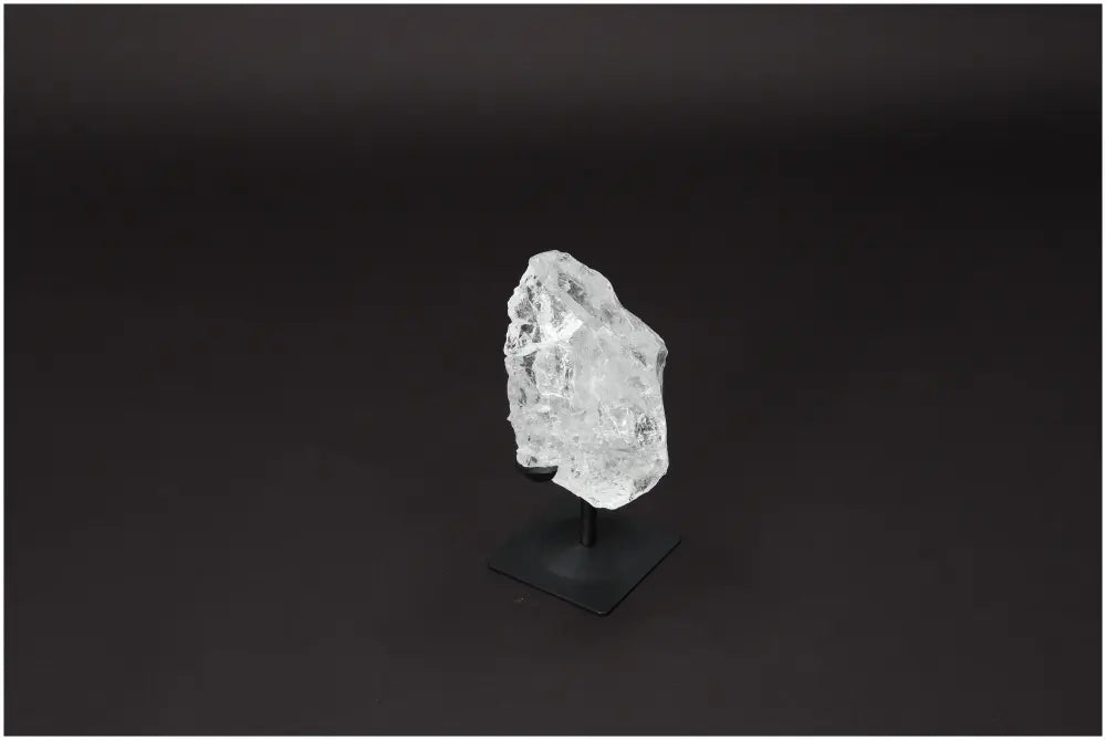 Rough Lemurian Quartz on metal stand showcasing its clear purity, ideal for energy balance and decorative use.