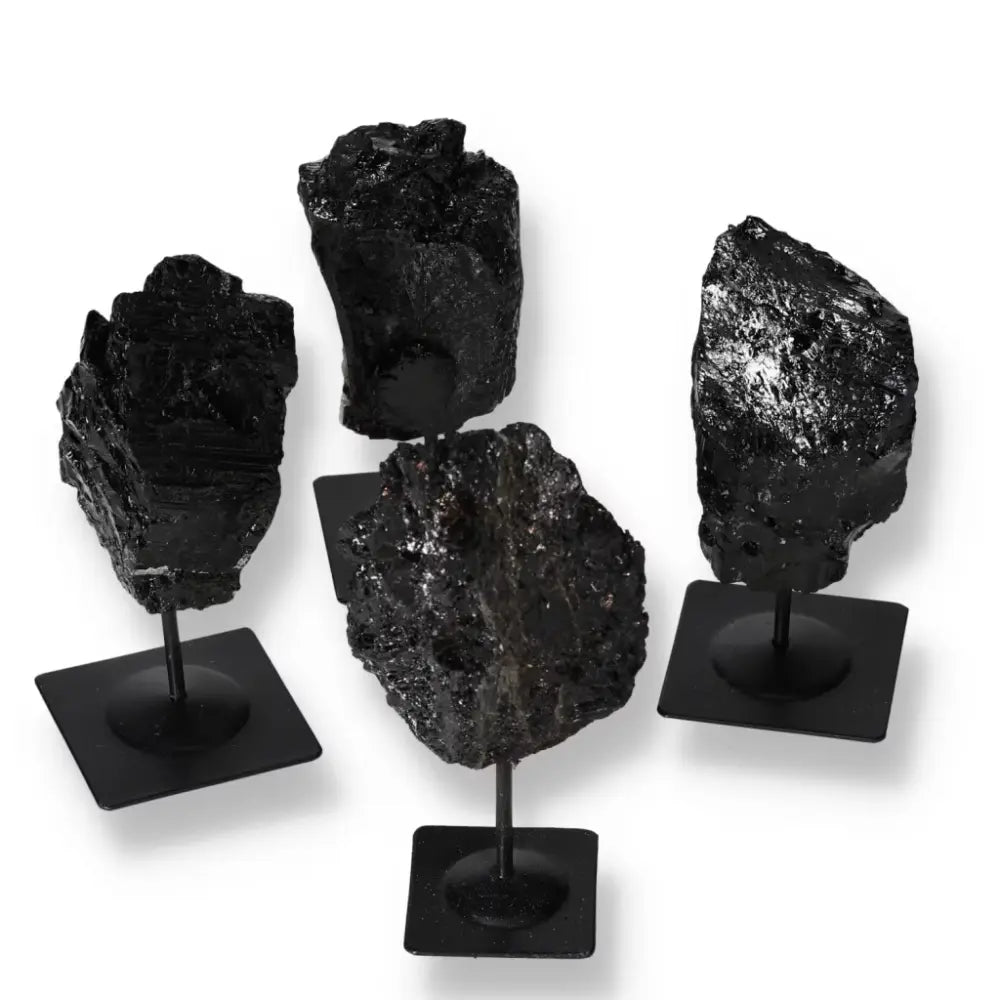 Rough tourmaline stones on metal stands showcasing natural beauty and elegance, available from Sylvia Crystals.