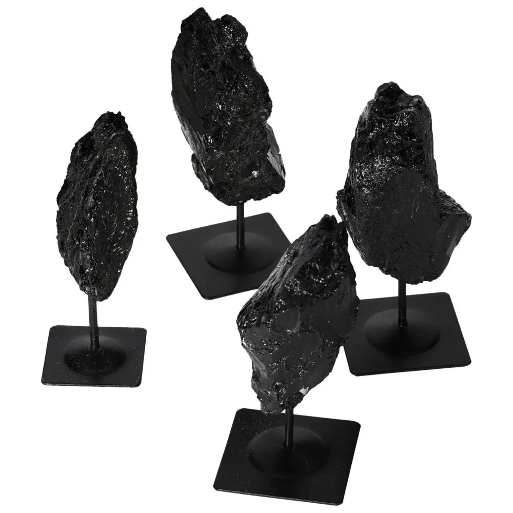 Rough tourmaline crystals mounted on sleek metal stands, showcasing deep black hues for home or office decor.
