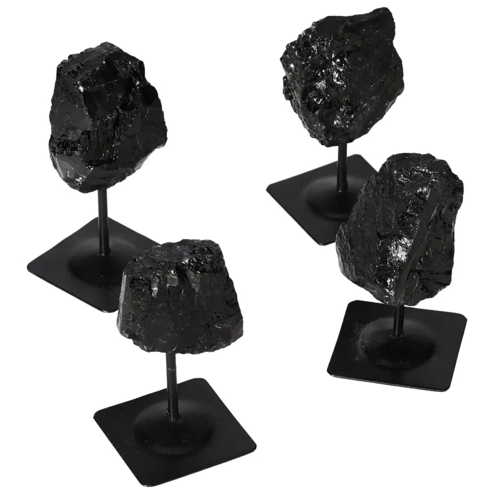 Rough black tourmaline stones on metal stands, showcasing unique textures and natural beauty, ideal for home decor and crystal enthusiasts.