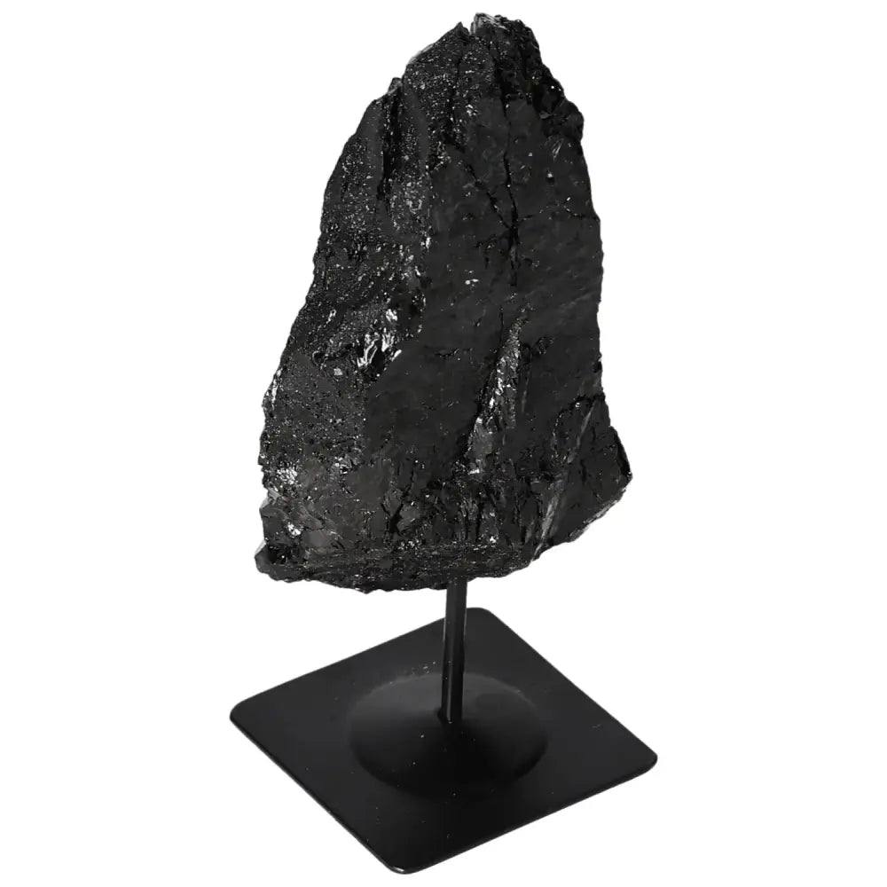 Black rough tourmaline crystal on metal stand, showcasing natural beauty and energy-harmonizing properties, Sylvia Crystals collection.