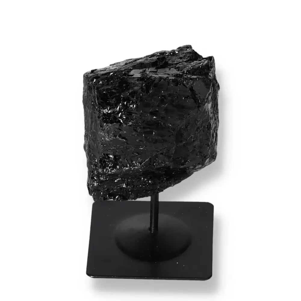 Rough black tourmaline crystal on a metal stand from Sylvia Crystals, showcasing nature's beauty in vibrant unrefined form.