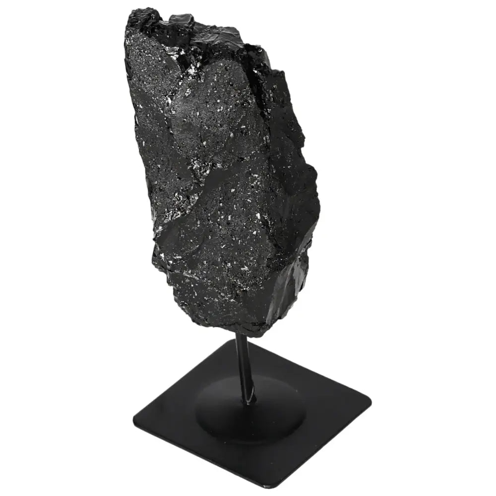 Rough black tourmaline gemstone on metal stand, highlighting natural texture and shine, by Sylvia Crystals.
