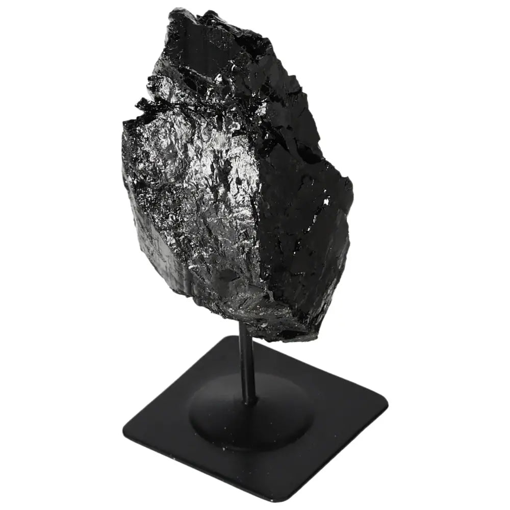 Rough tourmaline crystal on a sleek metal stand, premium decor piece by Sylvia Crystals, showcasing deep black hues and natural elegance.