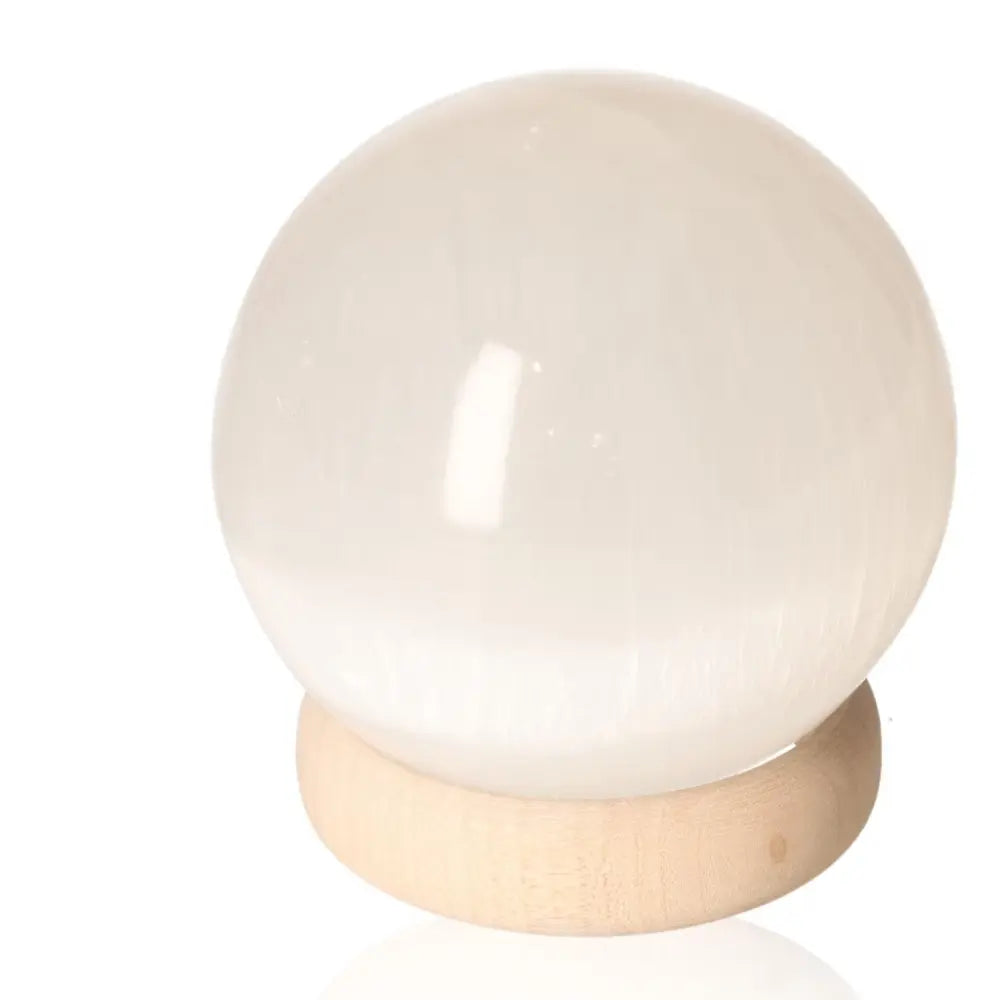 Selenite sphere by Sylvia Crystals, 10cm, on wooden stand - Perfect for mindful living and spiritual growth.