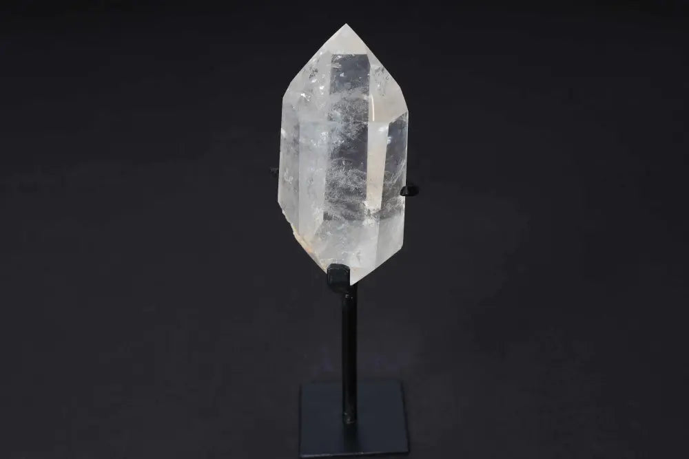 Semi polished clear quartz point on a stand for energy amplification and alignment.
