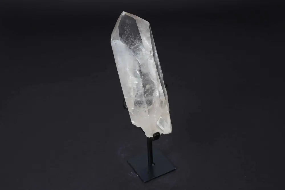 Semi polished clear quartz point on modern stand for energy amplification and meditation.