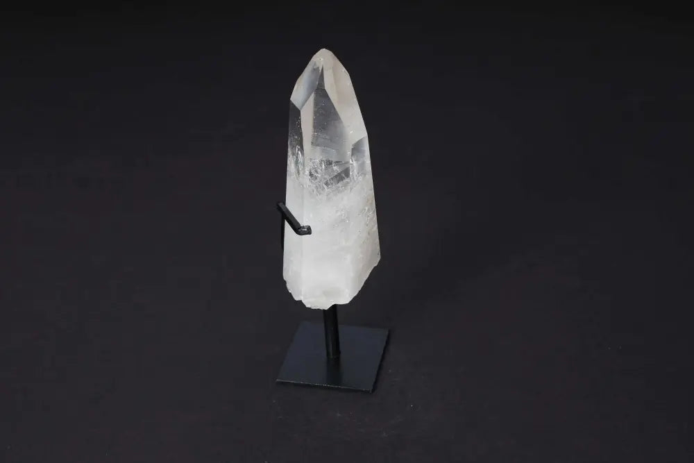 Semi polished clear quartz point on modern stand for meditation and energy amplification, perfect for clarity and manifestation.