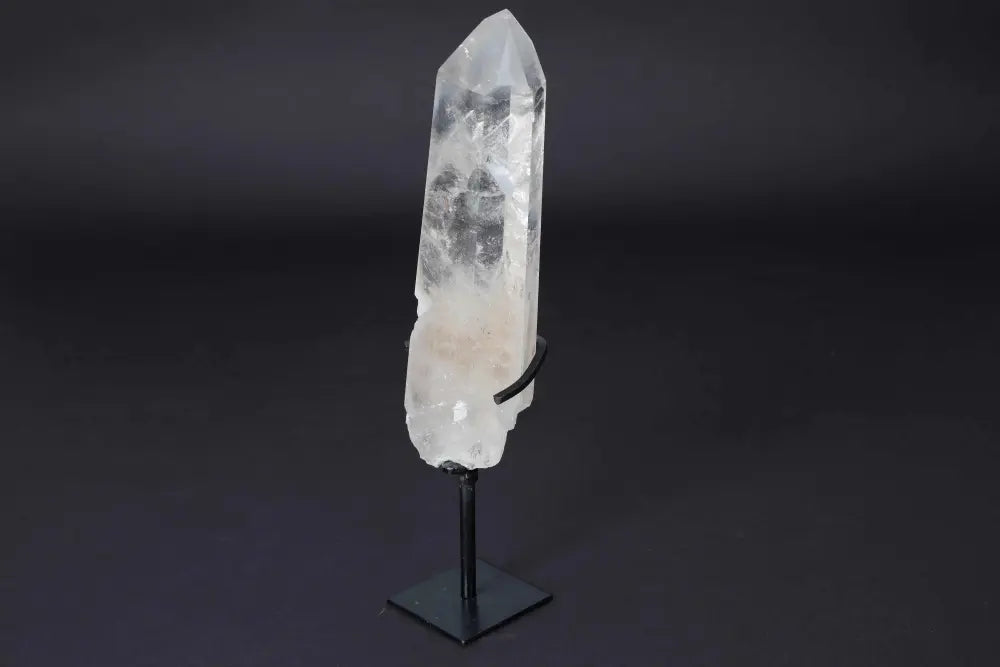 Semi-polished clear quartz point with stand, perfect for amplifying energy and clarity; ideal for meditation and home decor.