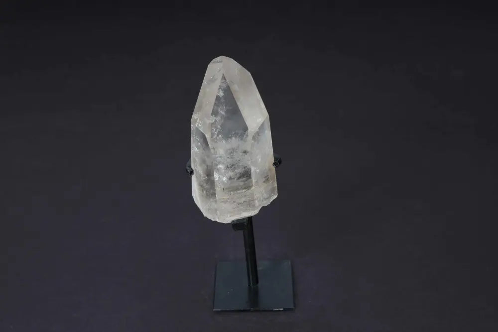 Semi-polished smoky quartz point with stand showcasing natural earthy tones and polished surfaces on a sleek display.