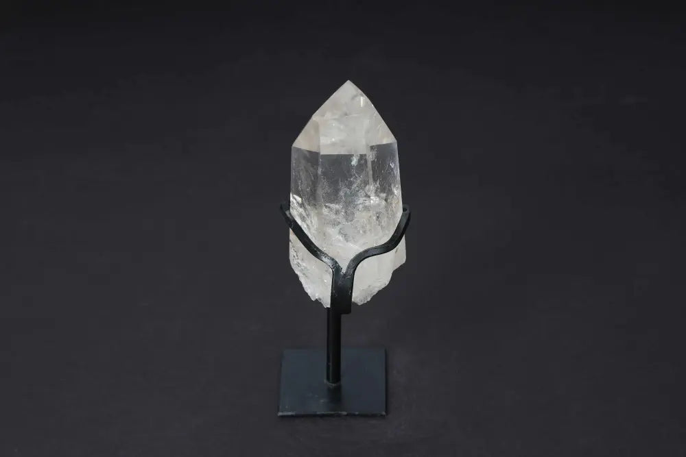 Semi-polished smoky quartz point with stand on dark background, showcasing its raw and polished surfaces.