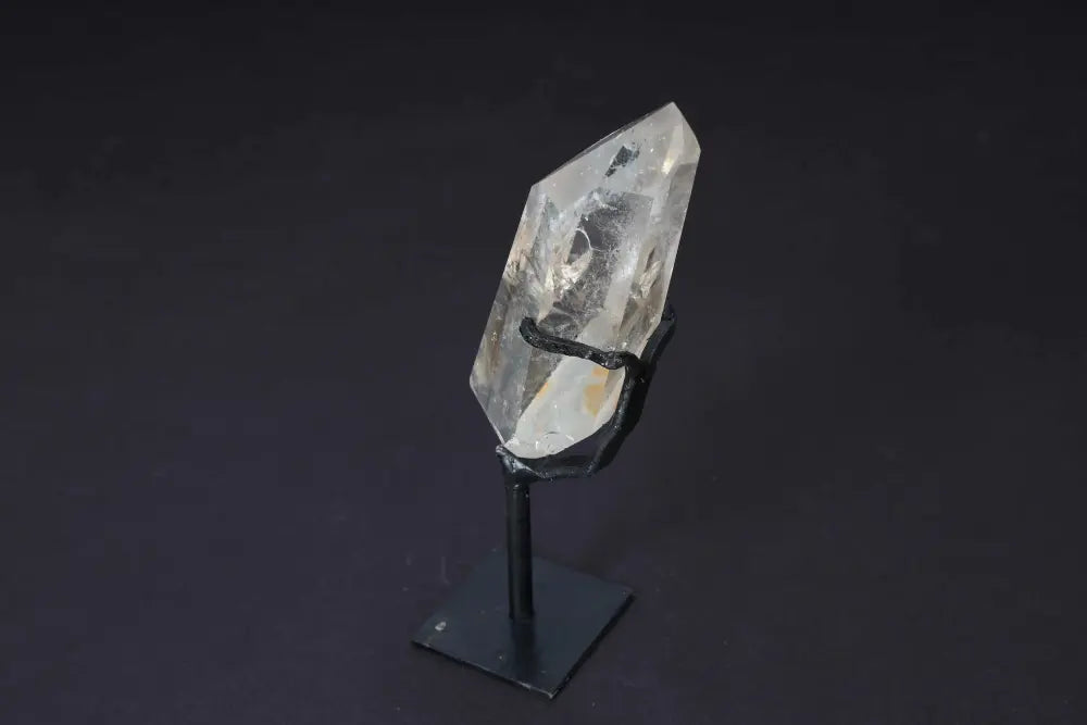 Semi-polished smoky quartz point on stand, showcasing rich earthy tones and natural raw edges for grounding and protective energy.