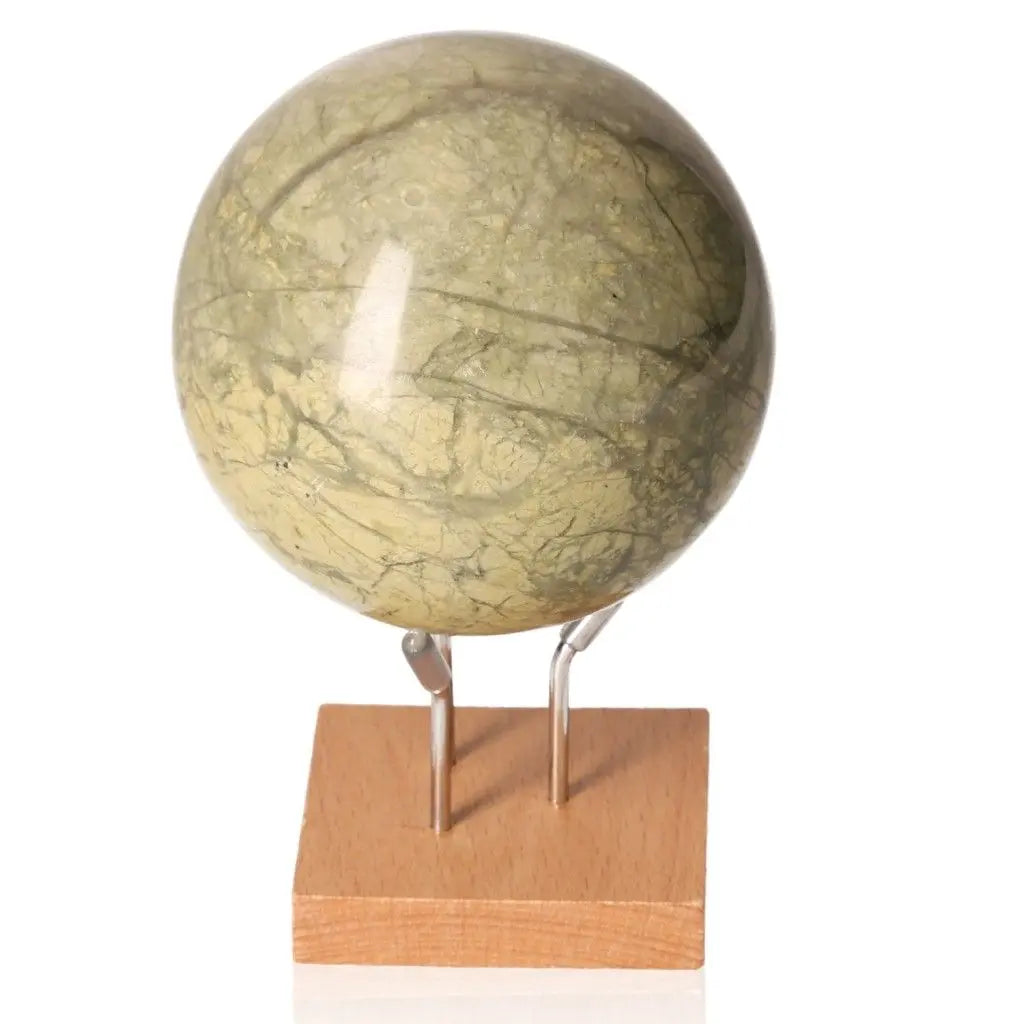 Serpentine Sphere on wooden stand, promoting tranquility, healing, and Heart Chakra activation.