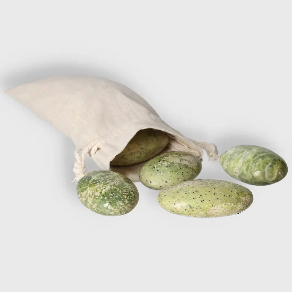 Serpentine palm stones in a cloth pouch, featuring vibrant green hues and smooth, polished surfaces for meditation and stress relief.