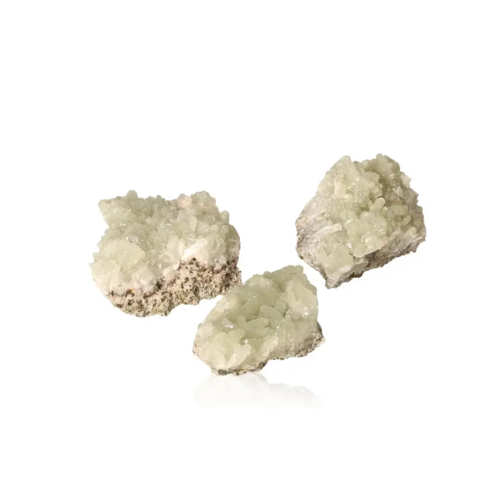 Three small prehnite druzy stones in pale green, known for their calming properties and spiritual enhancement.