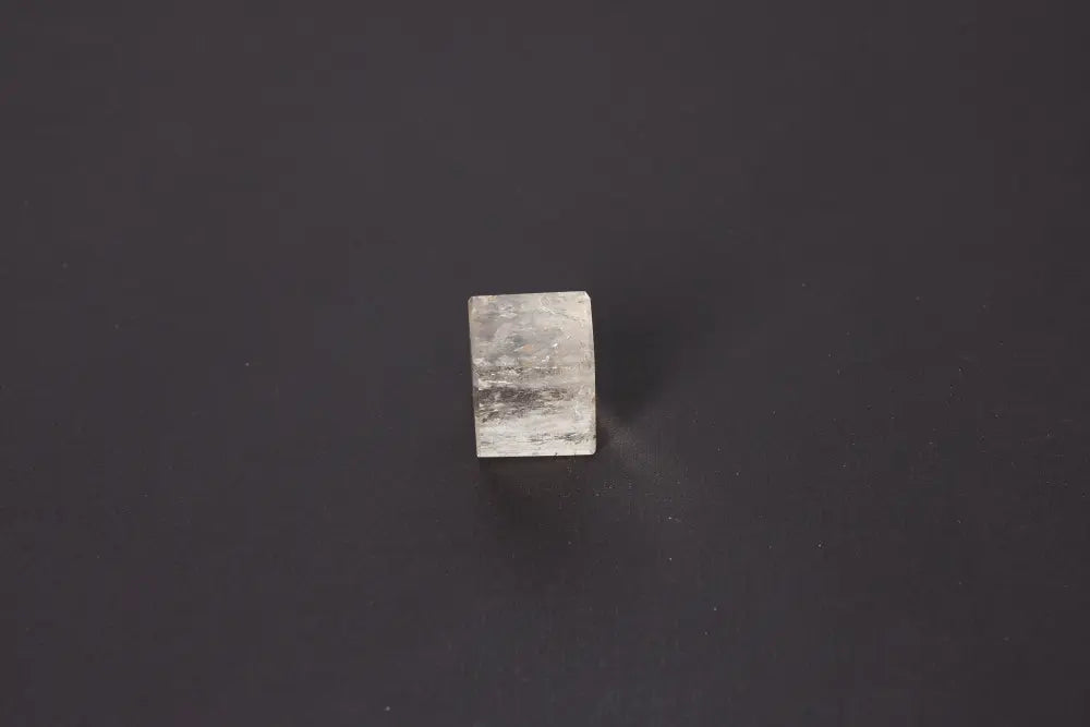 Smoky Quartz Cube 3 cm on dark background, showcasing its translucent gray tones and grounding energy properties.