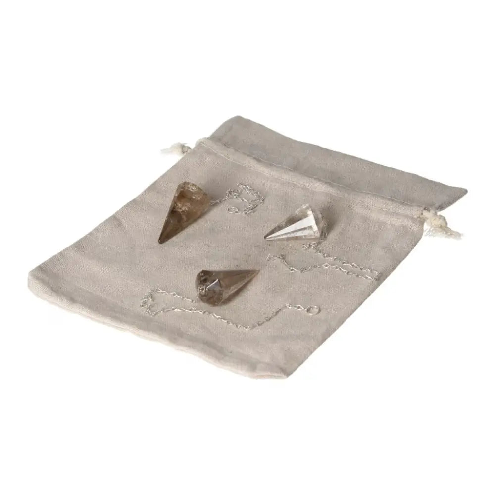Three Smoky Quartz pendulums on linen pouch for decision-making and stress relief.
