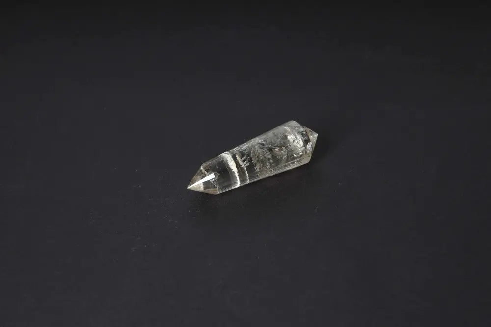 Polished smoky quartz point on black background, offering grounding and protective energy with its translucent brown hues.