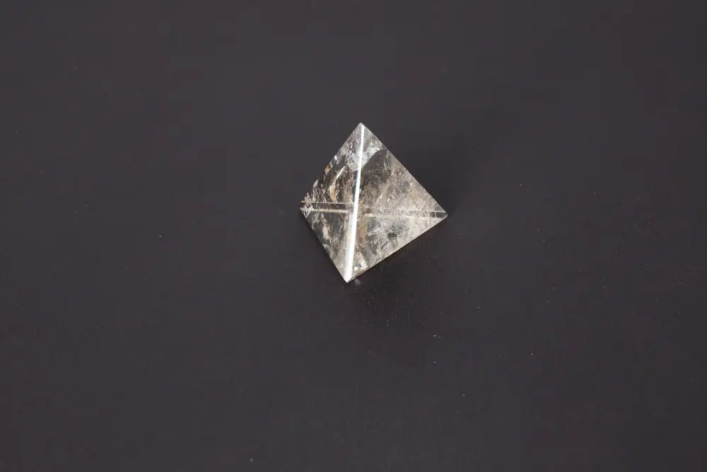 Smoky Quartz Pyramid 5 cm on dark background, showcasing its translucent gray and brown tones, ideal for grounding and protection.