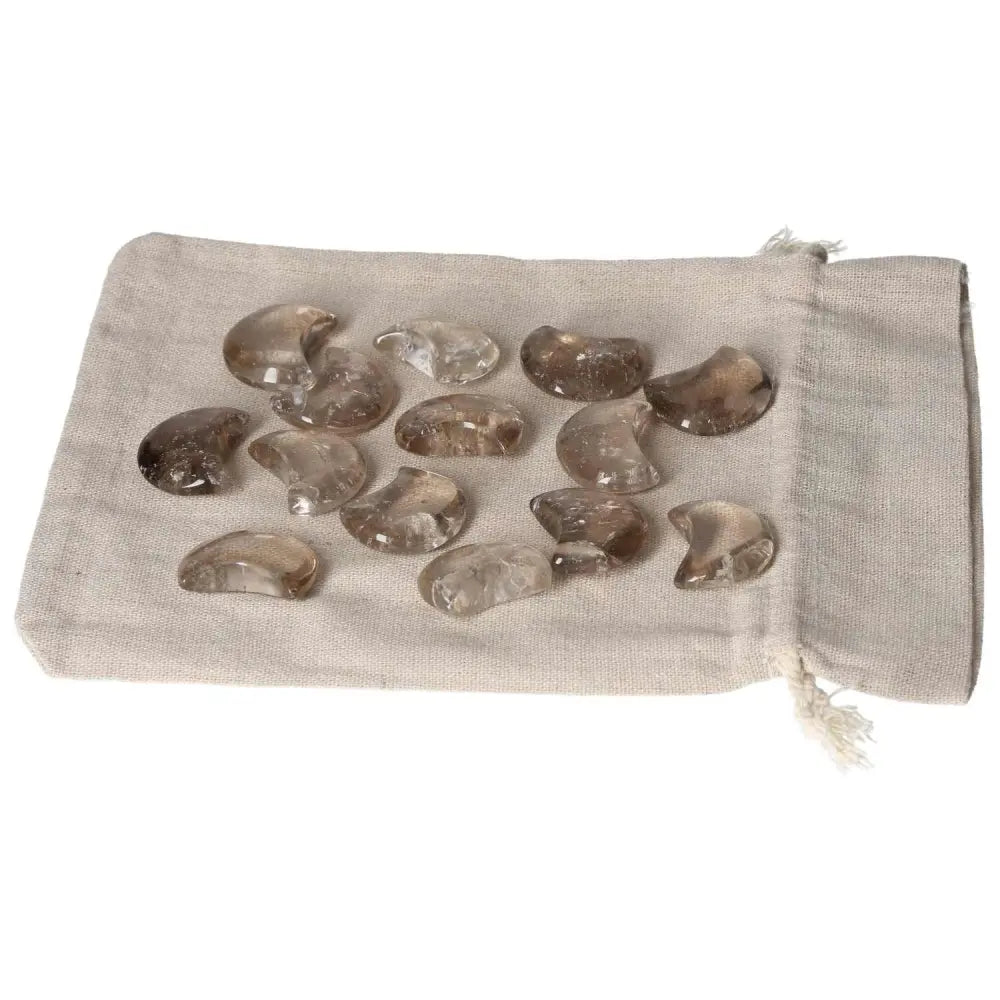 Smoky Quartz small moon stones on beige fabric, ideal for decision making and practical thinking support.