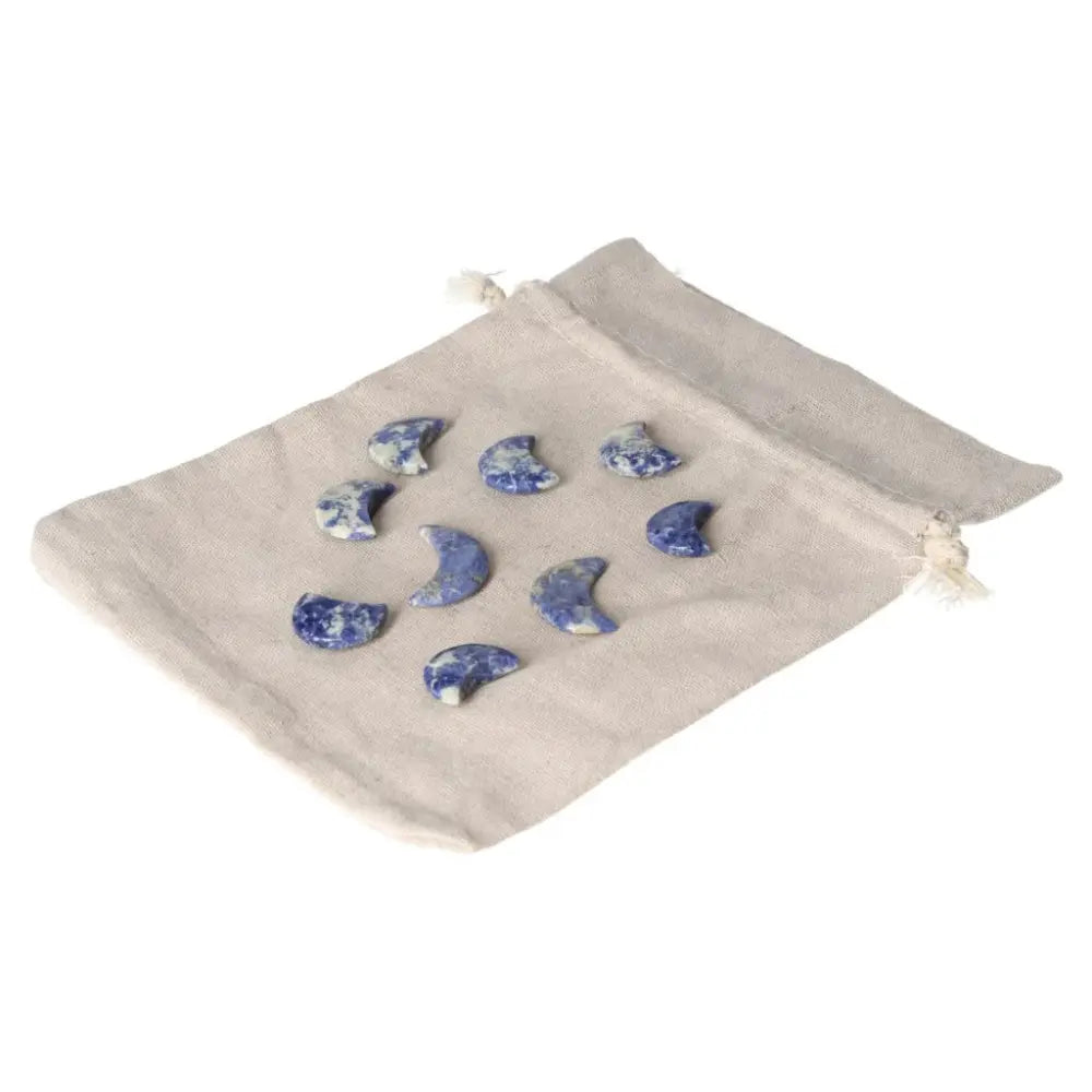 Small Sodalite moon stones on a beige pouch, symbolizing intuition, emotional balance, and calm with deep indigo and white marbling.