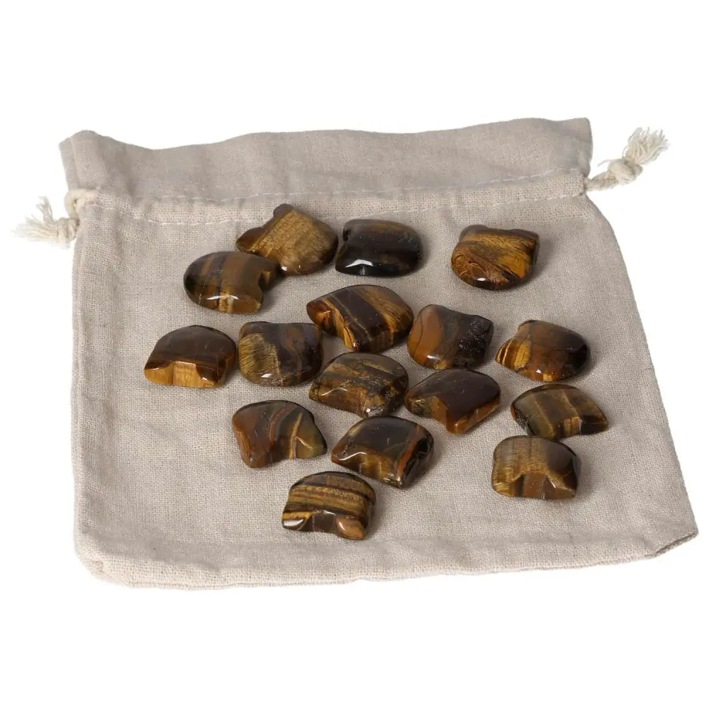 Small Tiger's Eye stones on a beige pouch, enhancing focus and security, aids in wealth management and business decisions.