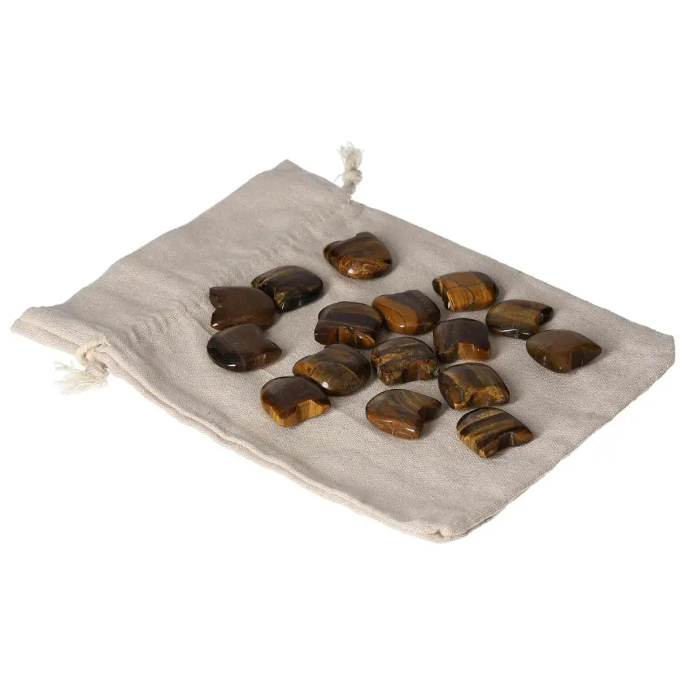 Tiger's Eye stones on a drawstring pouch, offering support for joy, stability, and focus, ideal for wealth management and mental clarity.