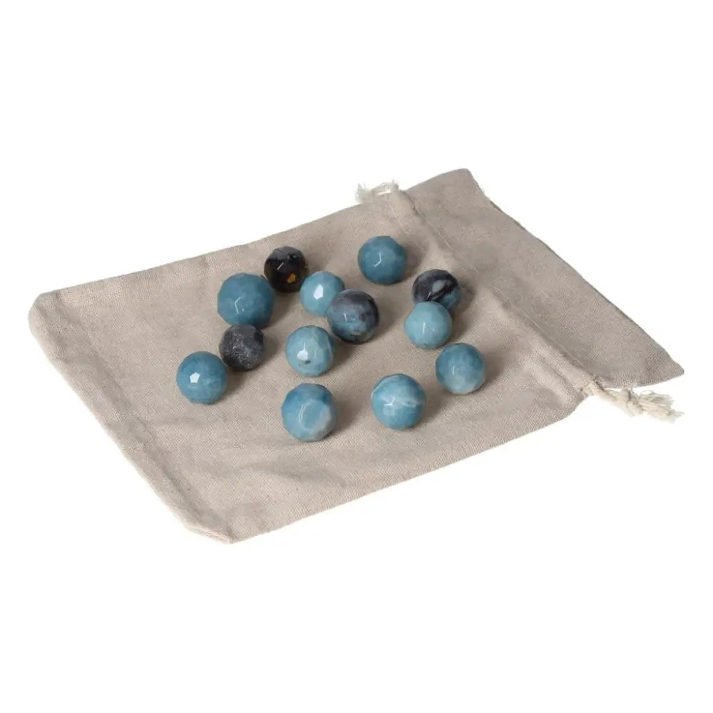 Trolleite small geometric spheres displaying varied blue hues on a beige cloth, ideal for spiritual awareness and intuition enhancement.