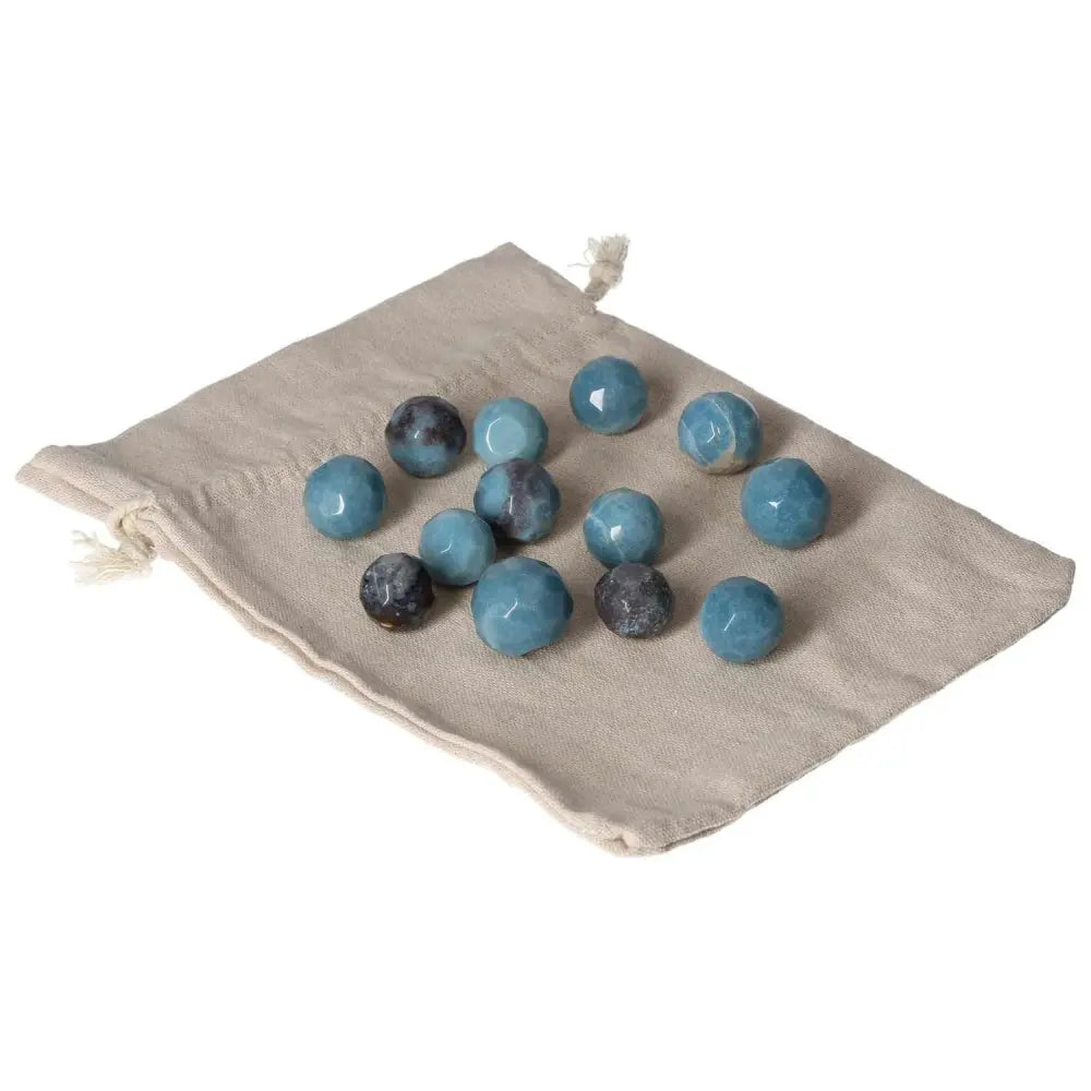 Collection of small blue Trolleite geometric spheres on a cloth bag, symbolizing spiritual awareness and intuitive growth.