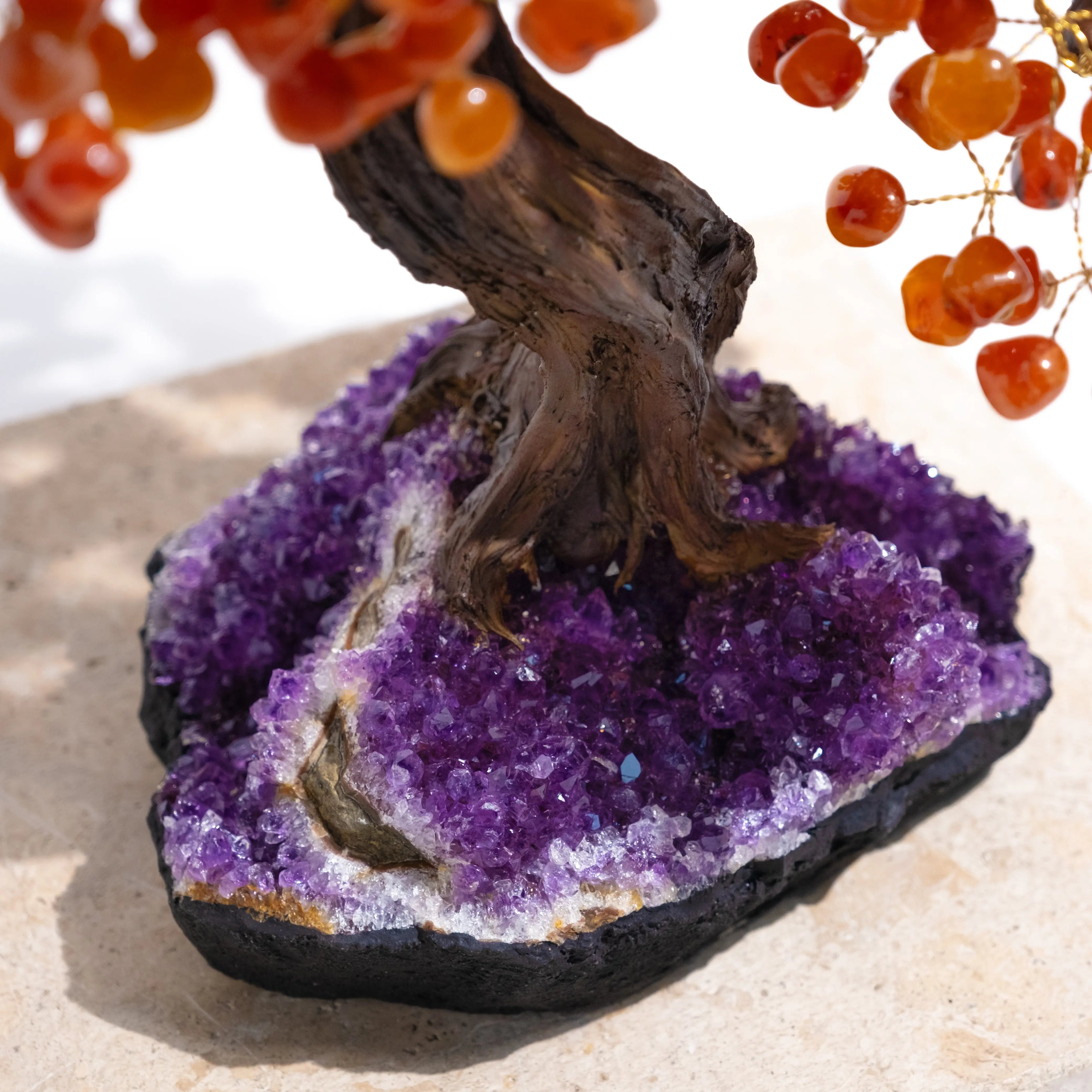 Close-up of a Tumbled Carnelian Bonsai Tree on a purple amethyst base, showcasing vibrant orange gemstones and a twisted trunk, 65cm tall.