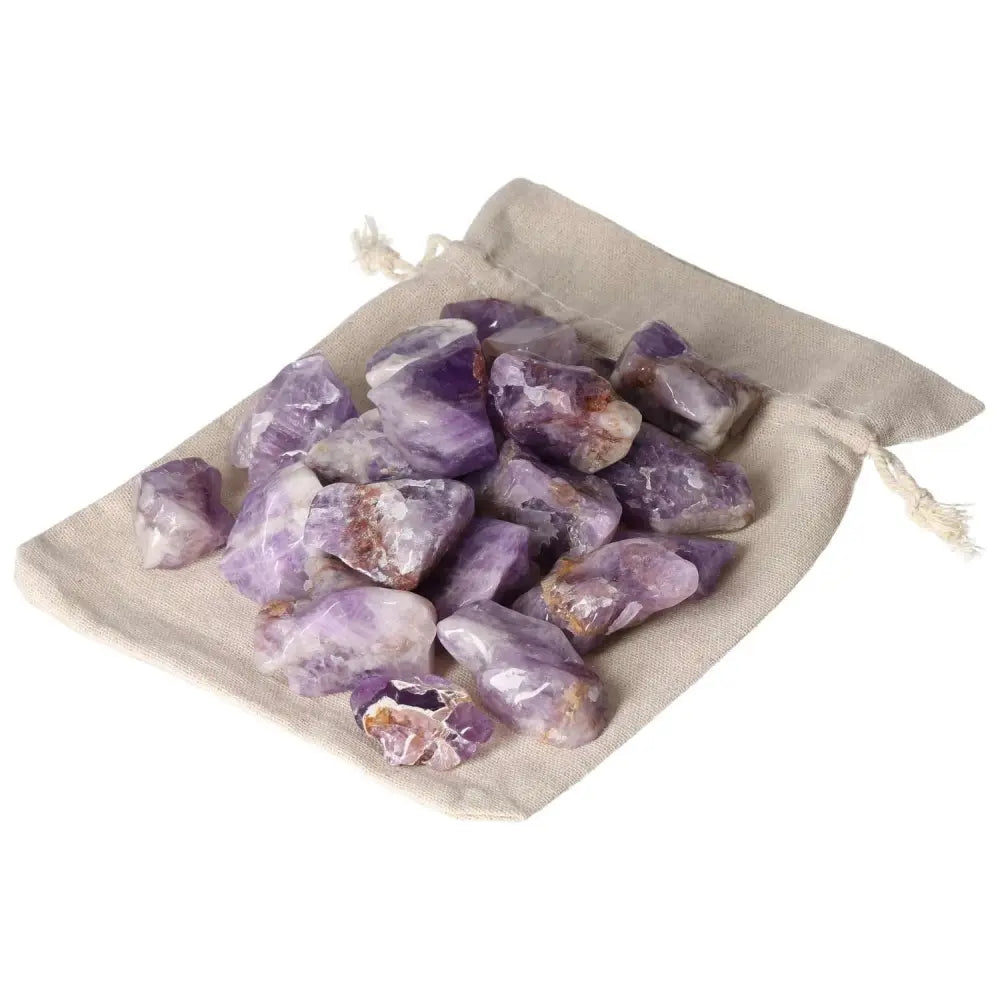 Tumbled Chevron Amethyst stones from Sylvia Crystals on a cloth bag, showcasing deep purple and white bands, symbolizing spirit and matter.