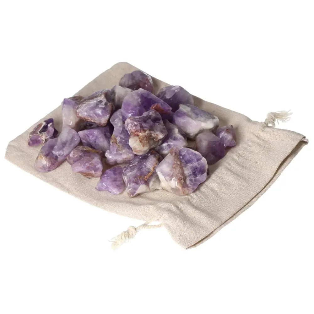 Tumbled Chevron Amethyst stones on a drawstring pouch, showcasing deep purple and white bands, from Sylvia Crystals.