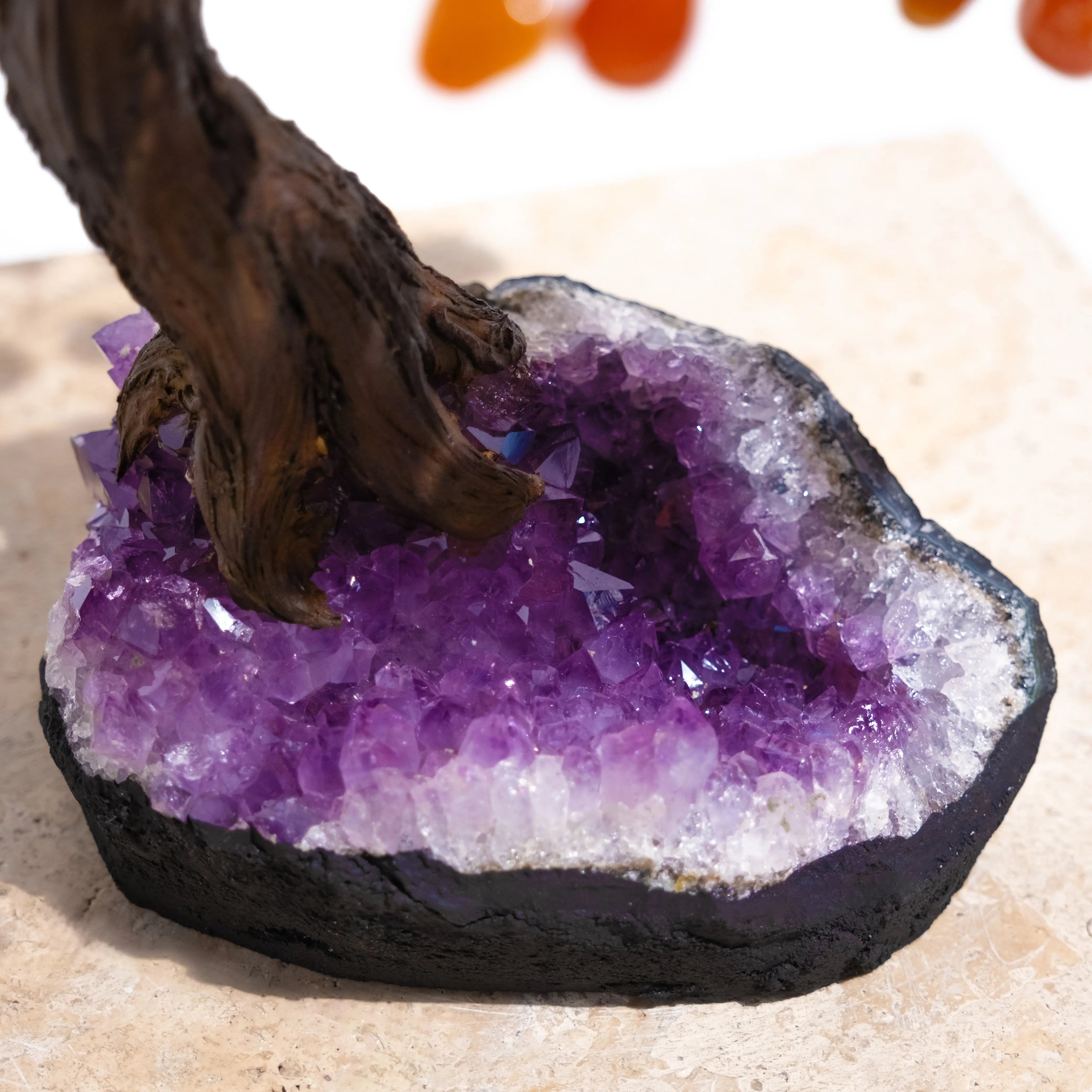 Amethyst geode base of a Tumbled Carnelian Bonsai Tree, enhancing positive energy and creativity with polished gemstones.